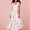 Midi dress with ruffle sleeves at the shoulders that merge around the scoop neck. The fitted smocked bodice releases into a midi skirt decorated with custom lace insets.