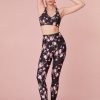 Black featuring pink floral print high-waisted leggings with a sleek style and feature a smocked waistband for a seamless performance.