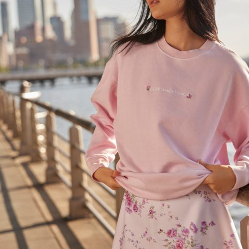 light pink Crewneck pullover sweater with embroidered flowers near the neckline and LSF logo at the sleeve cuff