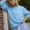 Blue Crewneck pullover sweater with embroidered flowers near the neckline and LSF logo at the sleeve cuff