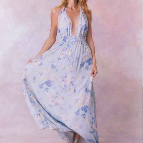 Blue backless floral halter maxi dress that ties in the back, flowing into an airy skirt.