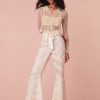 Floor length flare pants with laces and textural shirring details all over. Features a satin ribbon waistband with a self-tie.